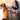 Golden retriever harnessed in a car with a red dog seat-belt tether clipped into the seat-belt buckle